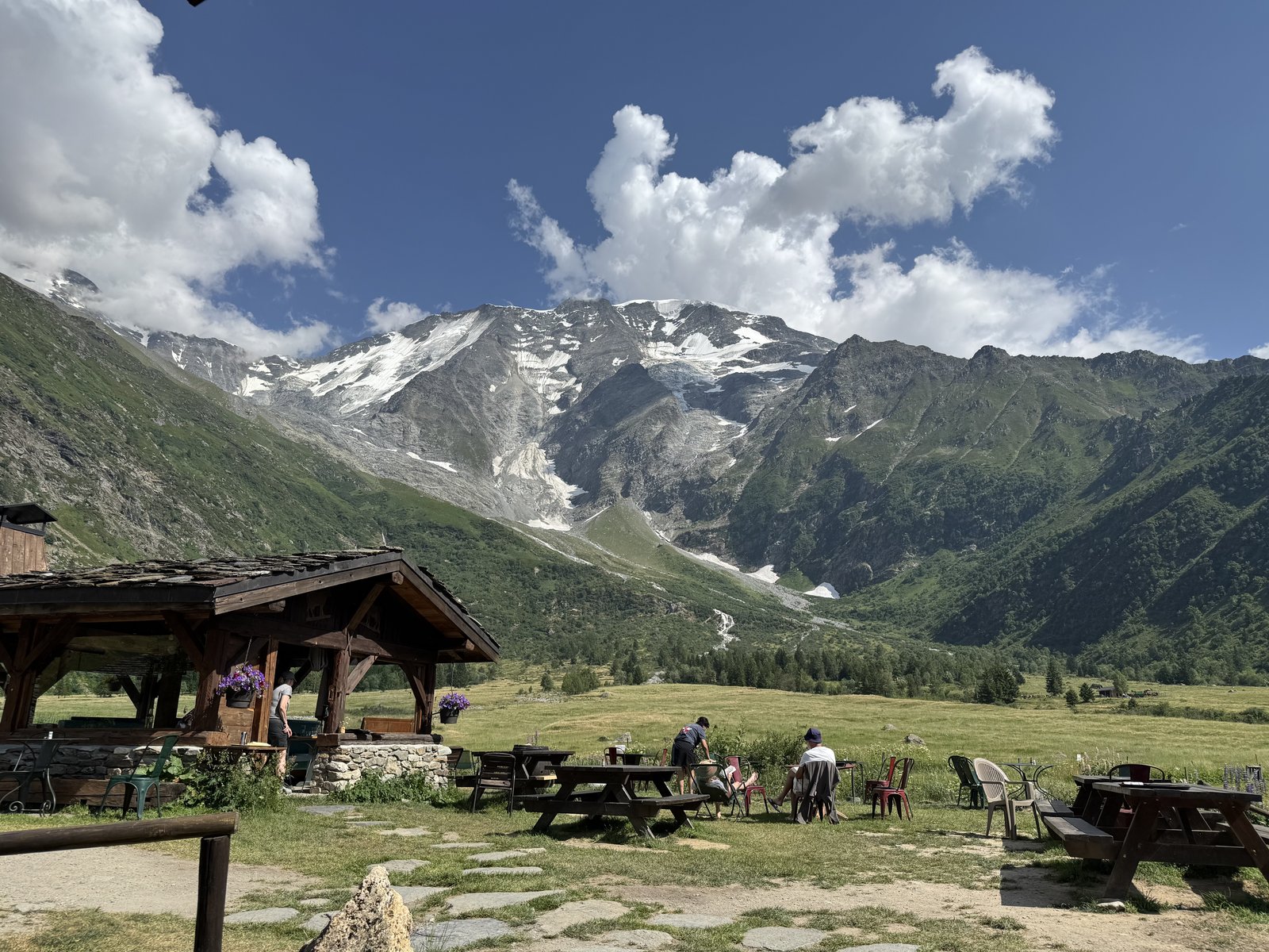 Een koppel zit samen bij een alpinehut en kijkt naar de bergen