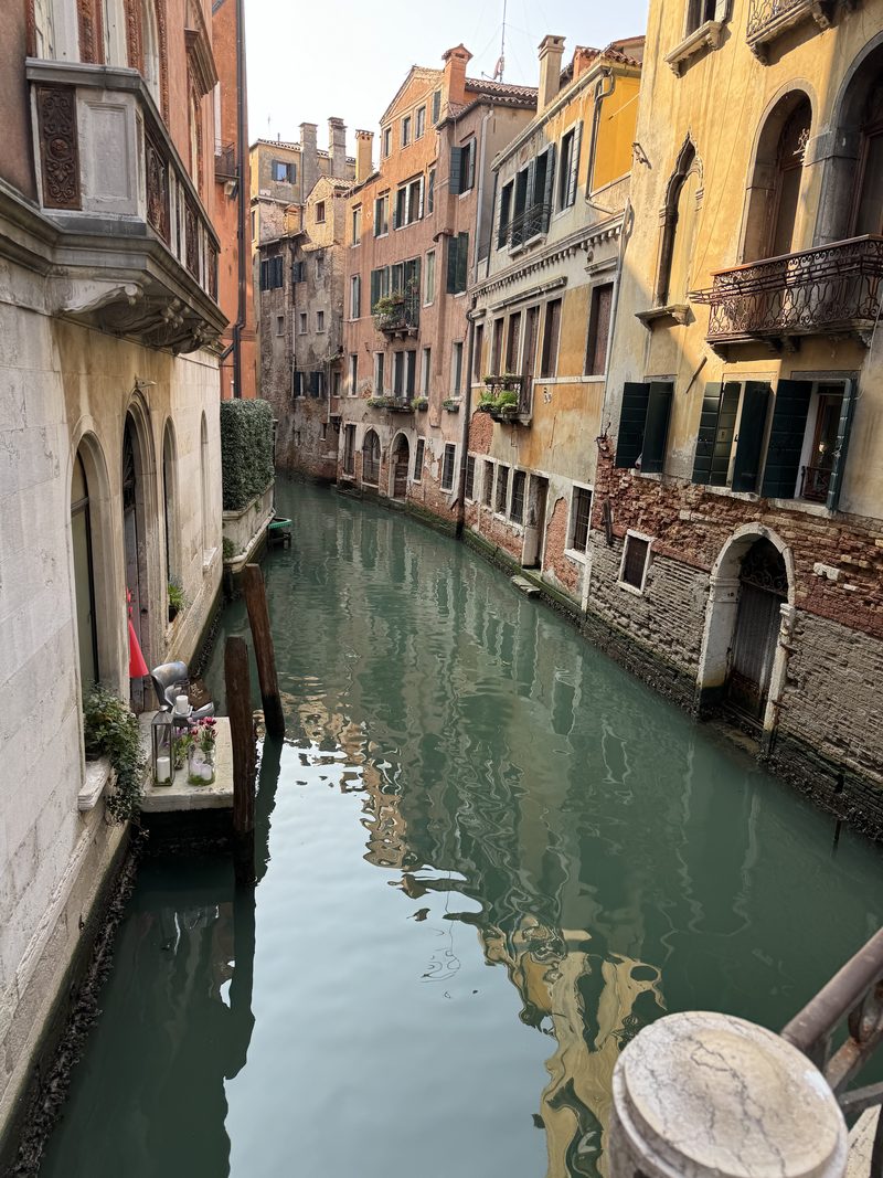 A quiet canal between weathered houses in Venice